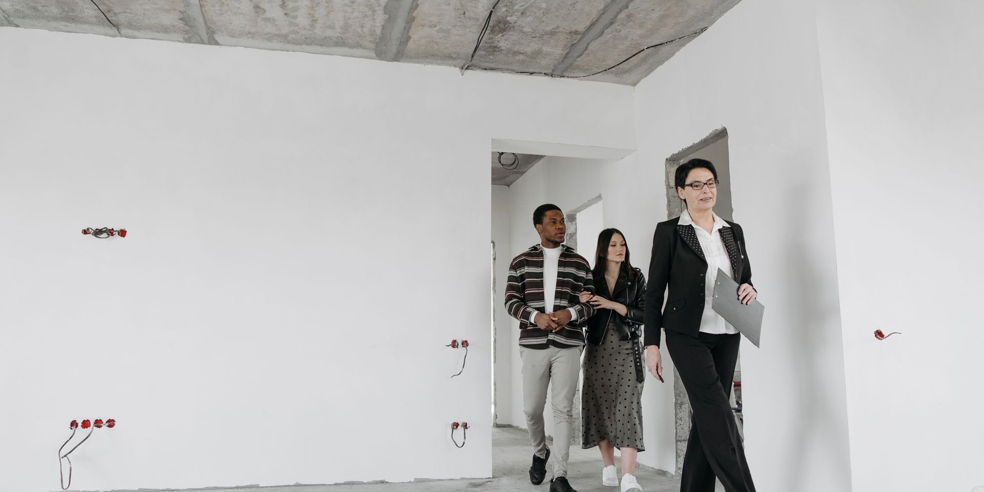 A group of people are walking through an empty room.