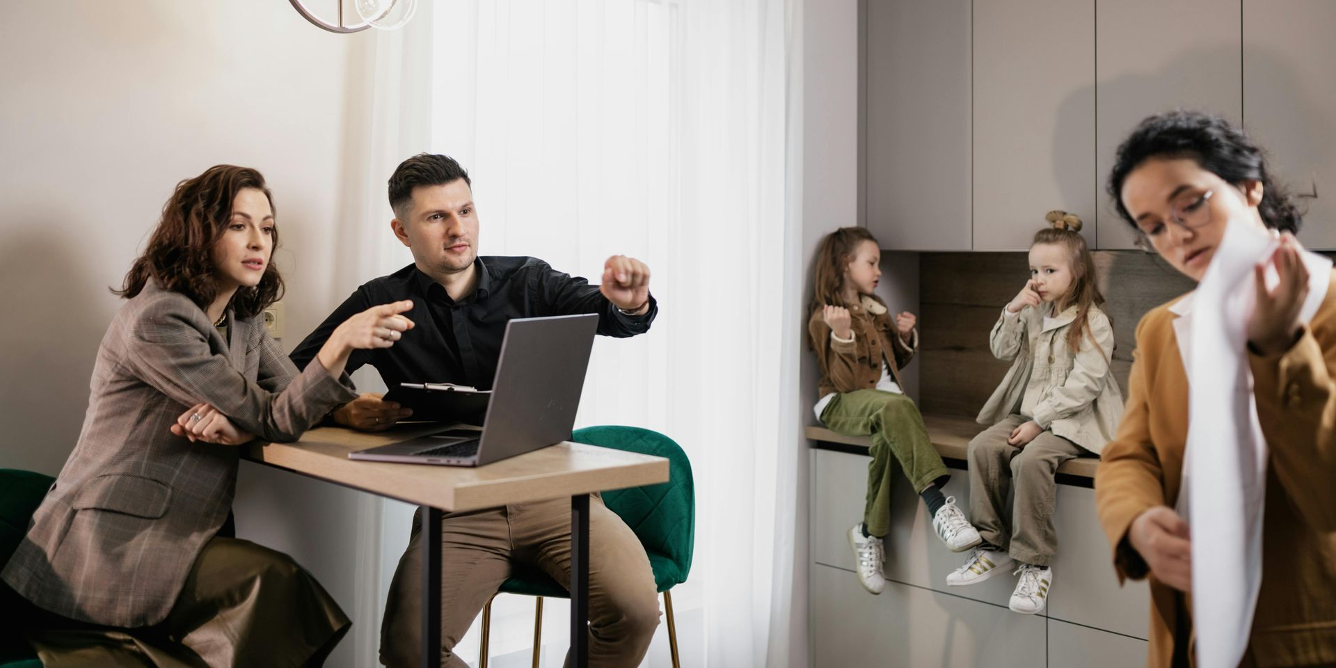 A person in a safety vest cleans leaves from a gutter on a house roof with a ladder.