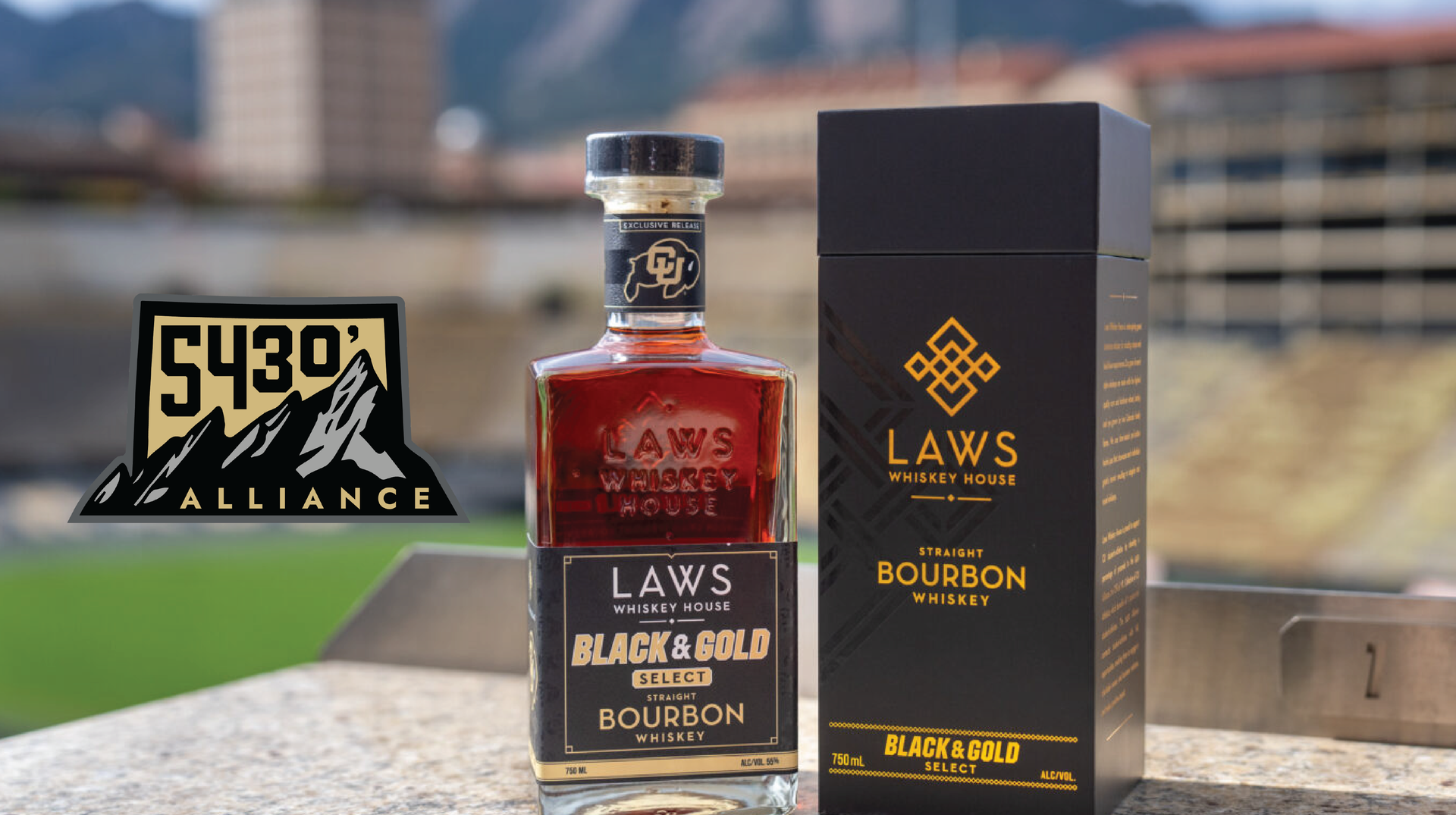 A bottle of laws black gold bourbon next to a box.