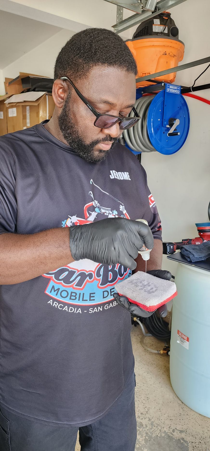 A detailer applying ceramic coating to an applicator. 