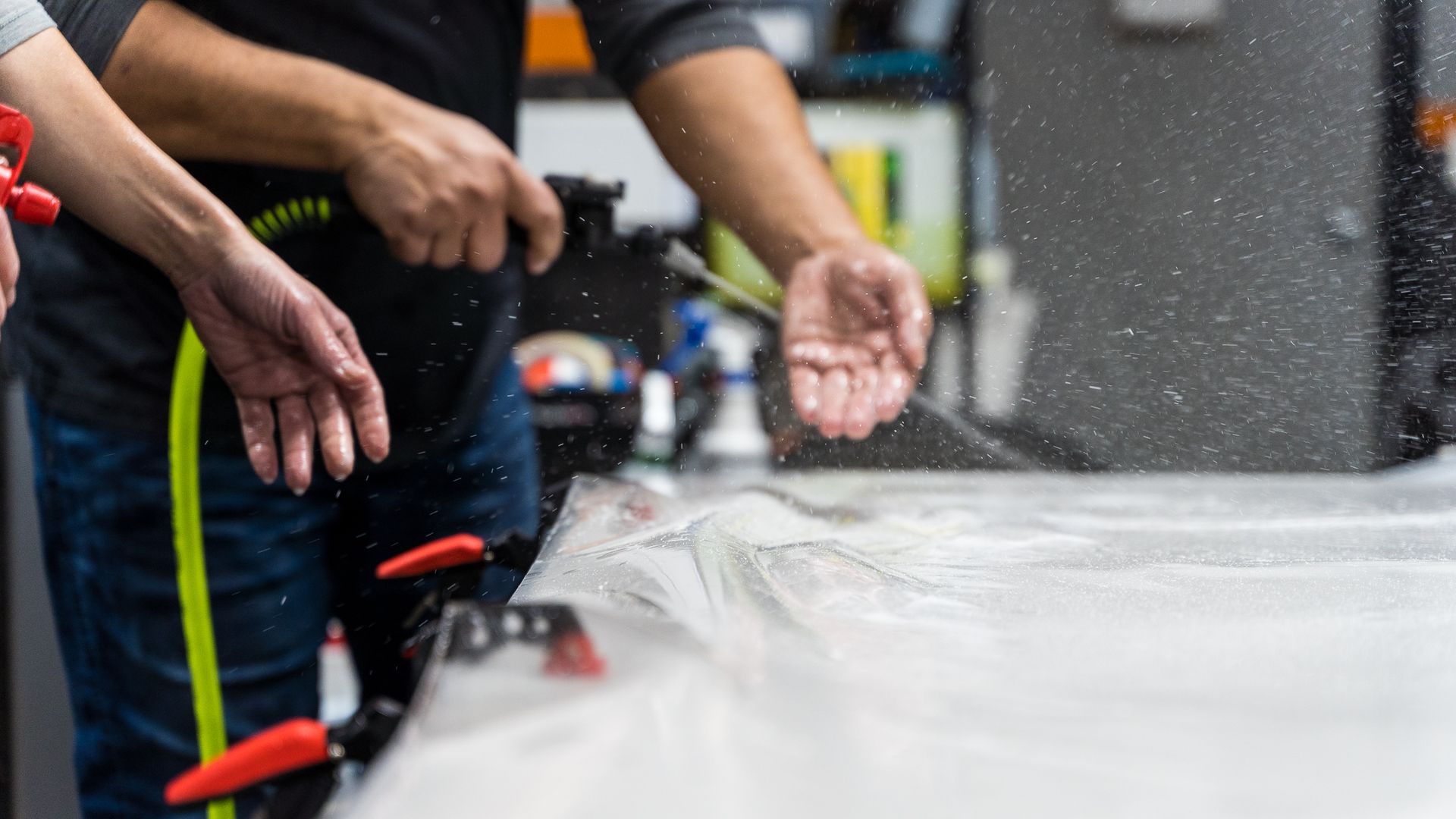 A man is cutting a piece of plastic with a pair of scissors.