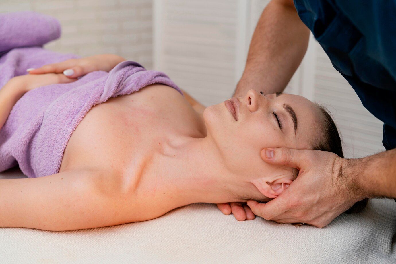 Une femme reçoit un massage de la tête dans un spa.