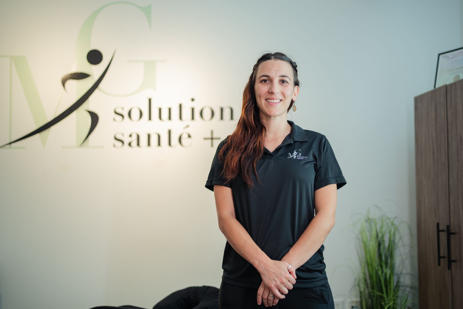 Une femme portant des lunettes et un foulard sourit sur une photo en noir et blanc.