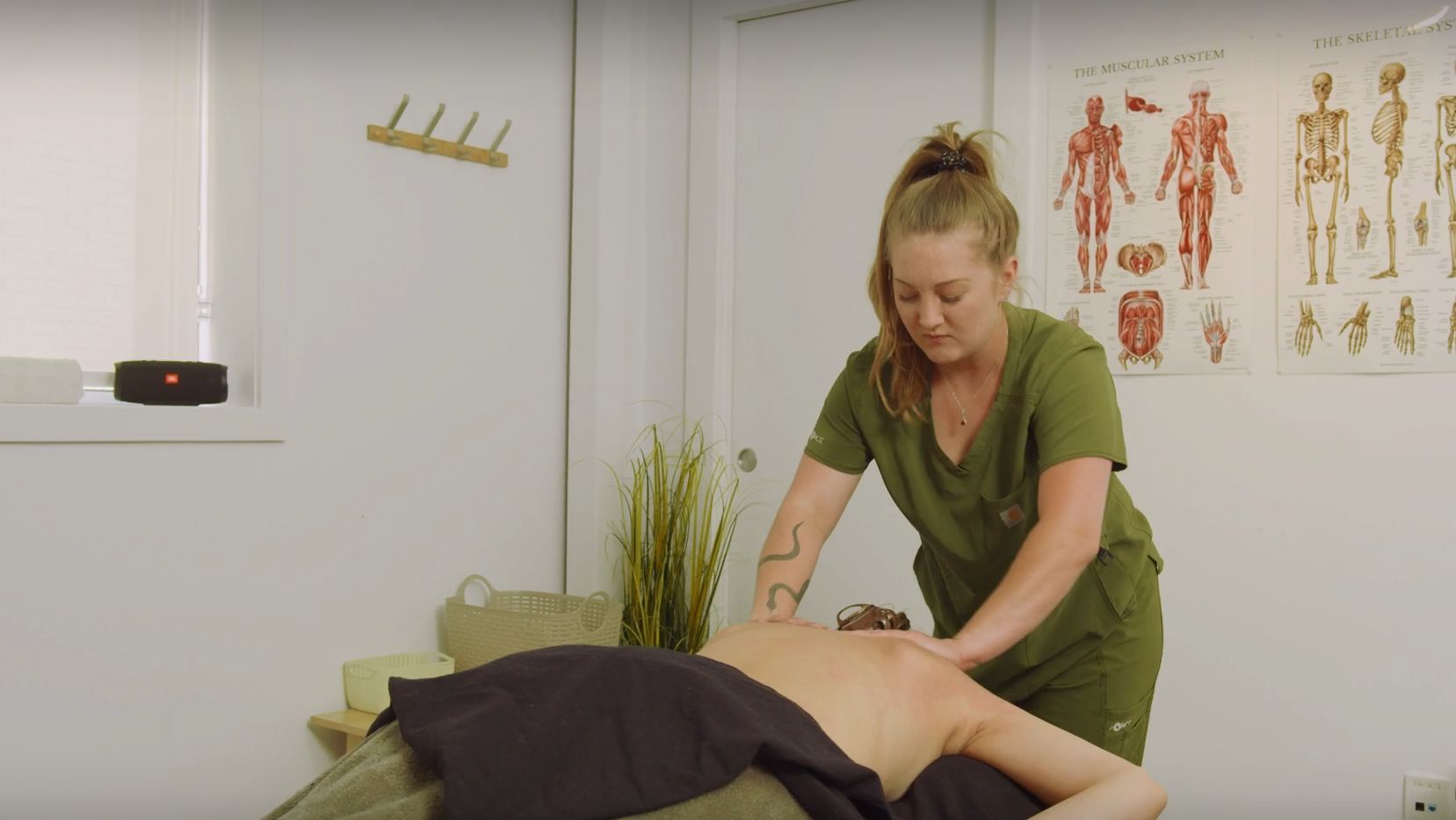 Une femme donne un massage à un homme dans une pièce.