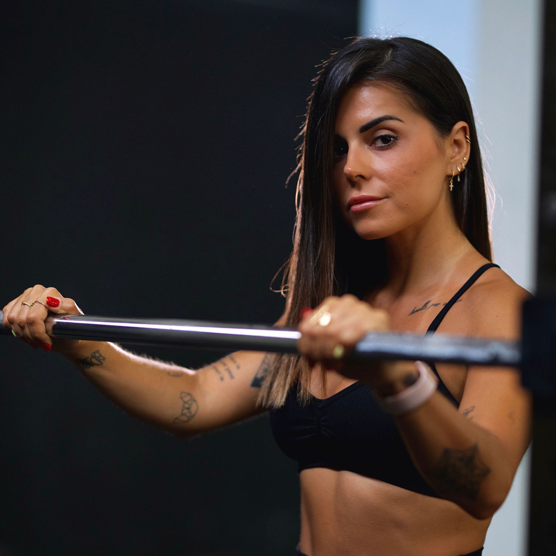 A woman is squatting on a yoga mat while holding a dumbbell. Forever Fit - Personalised Workouts and Nutrition