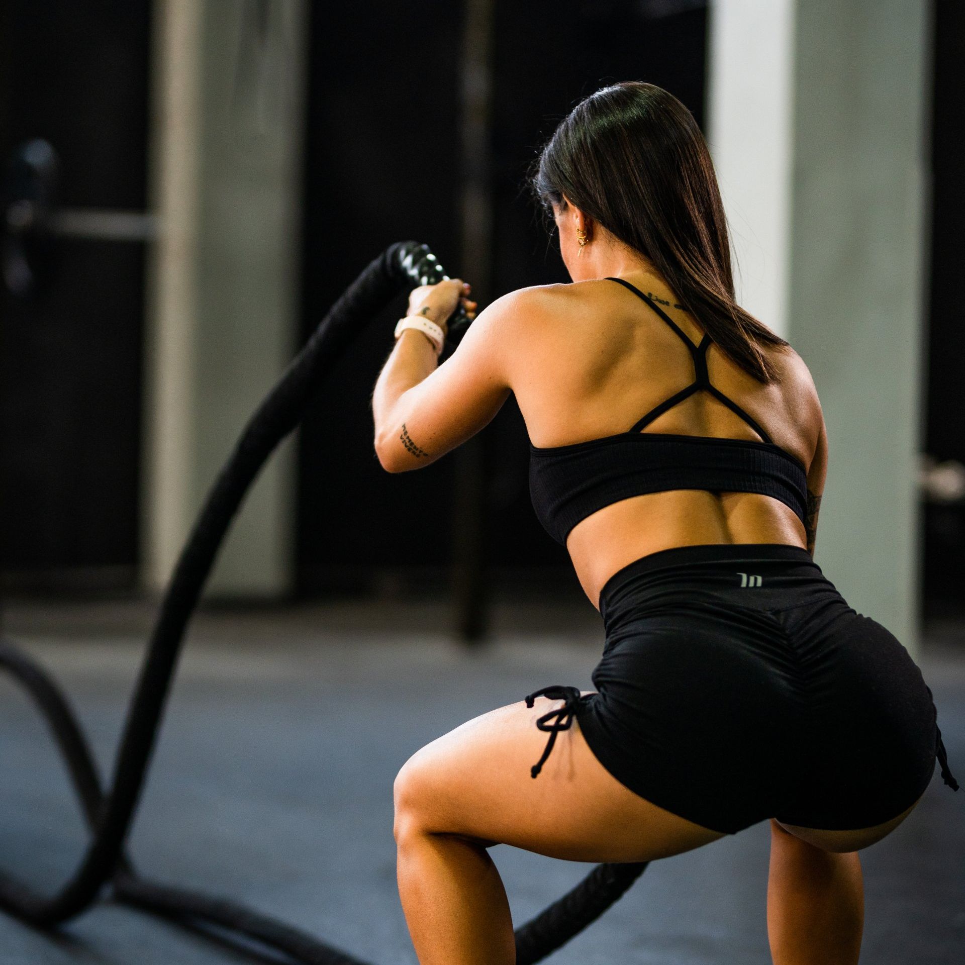 A woman in a grey jumpsuit is holding a black ball. Forever Fit - Personalised Workouts and Nutrition - Terrina Brewer