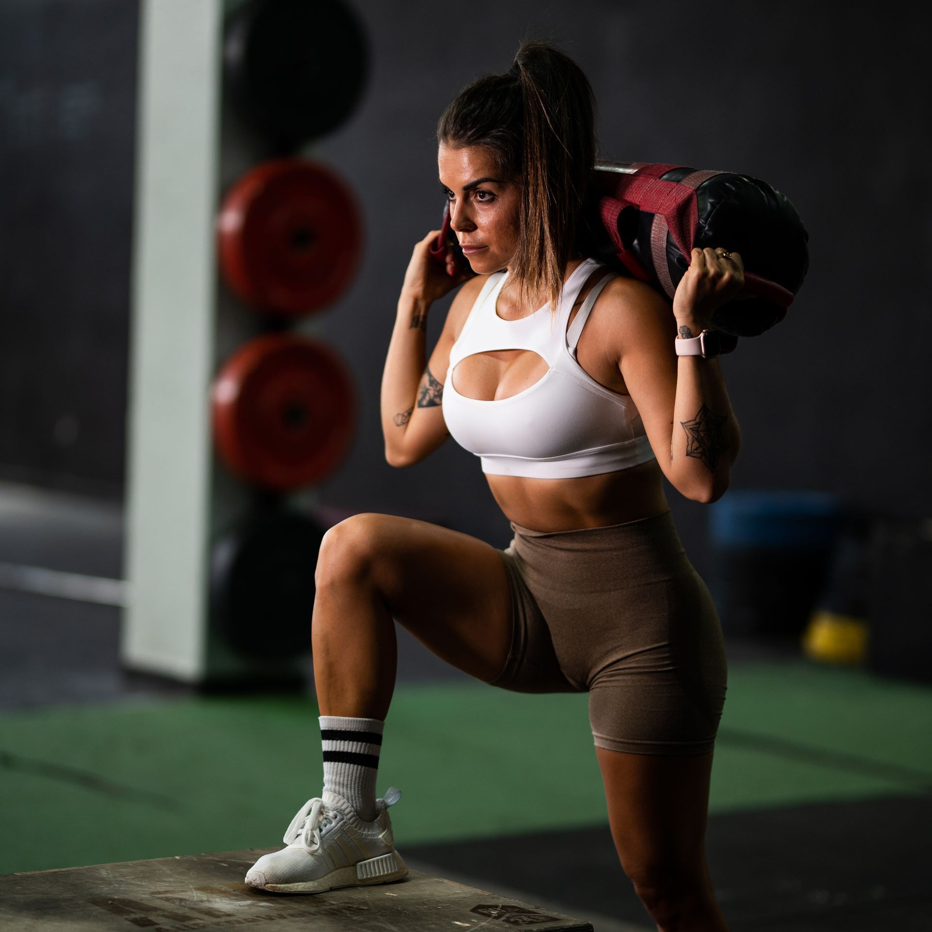 A woman is doing a plank exercise with a dumbbell over her head. Forever Fit - Personalised Workouts and Nutrition