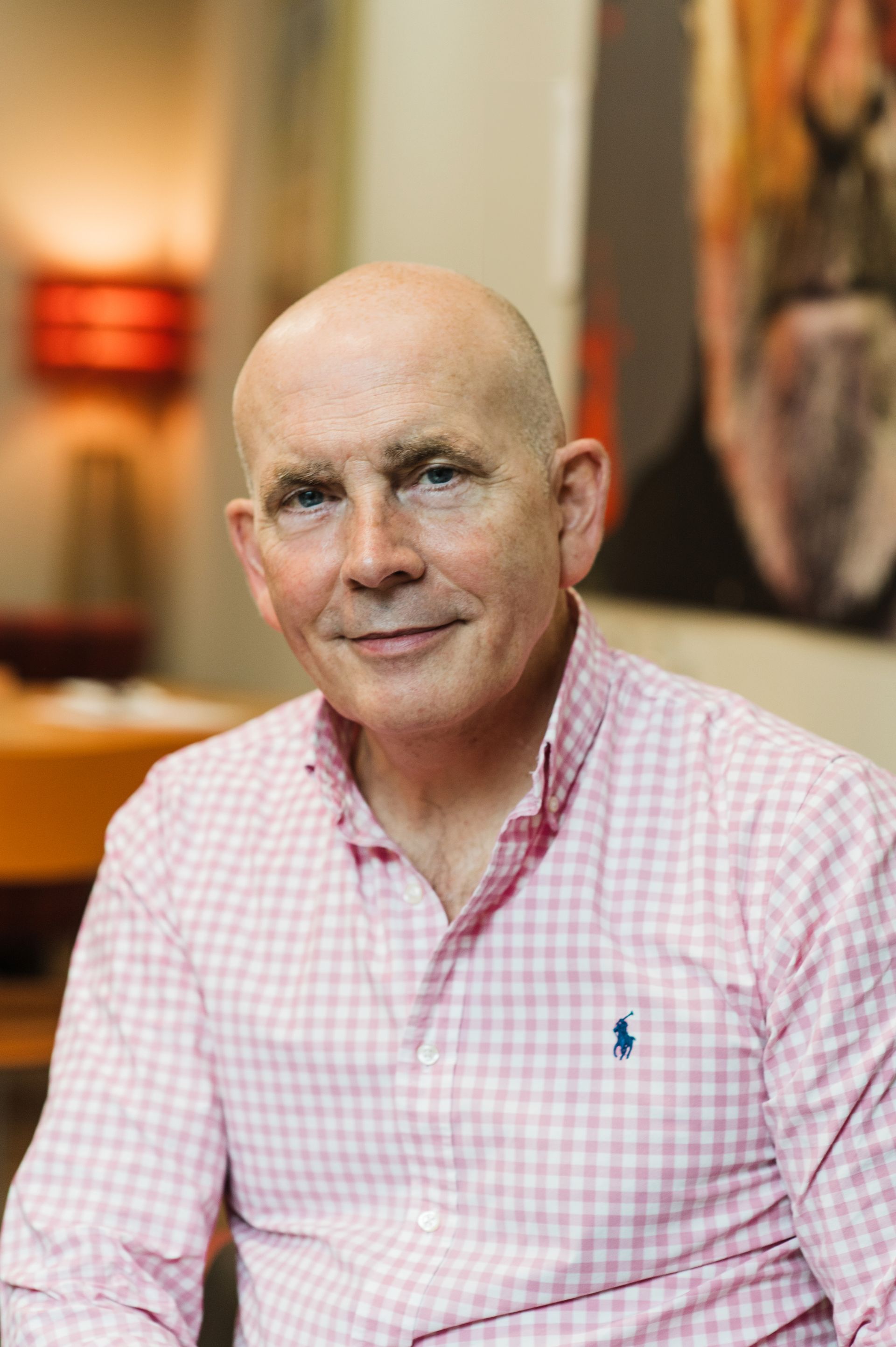 Smiling white man, bald, wearing a pink and white check shirt