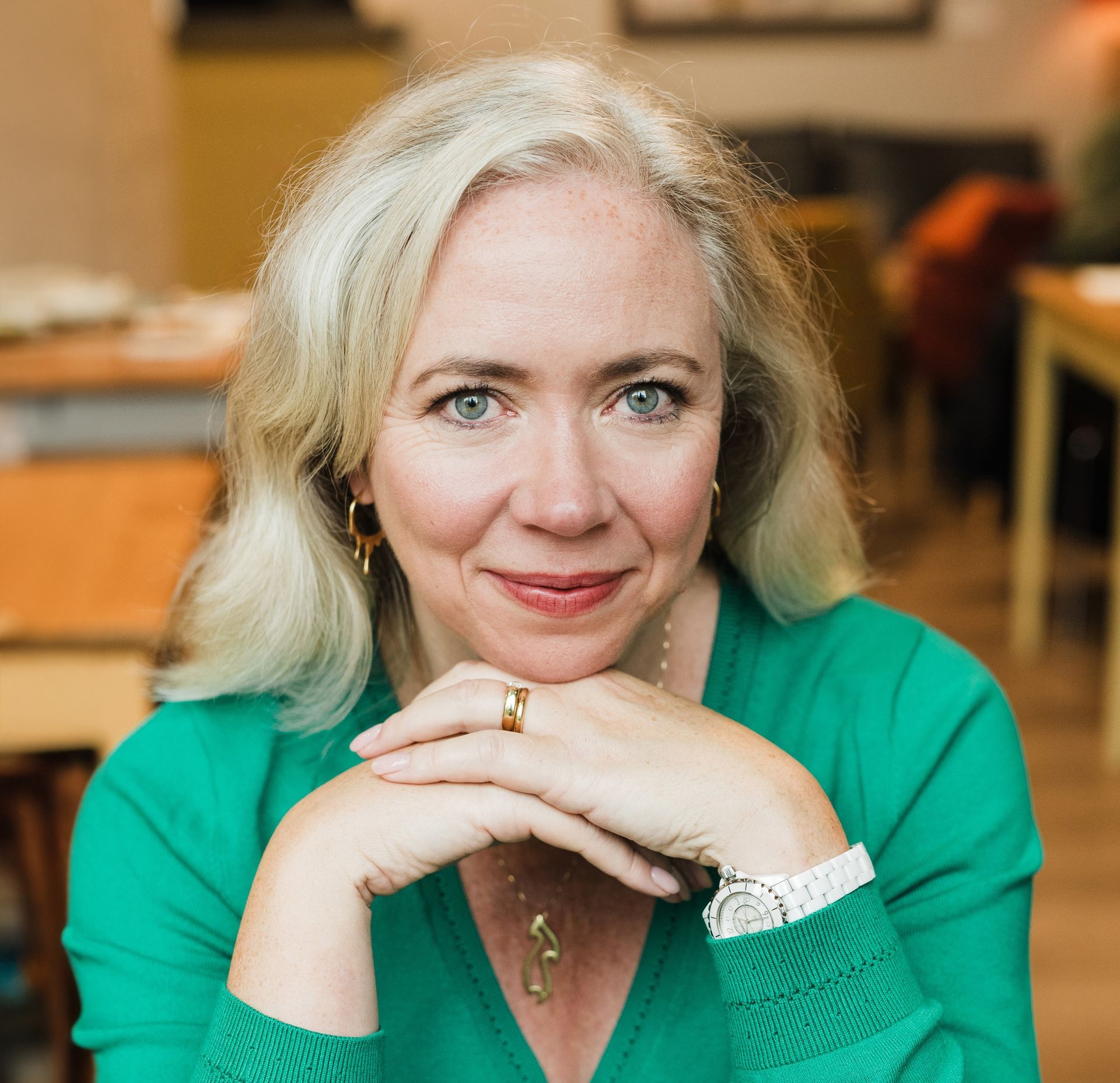 Smiling blonde women wearing a bright green jumper