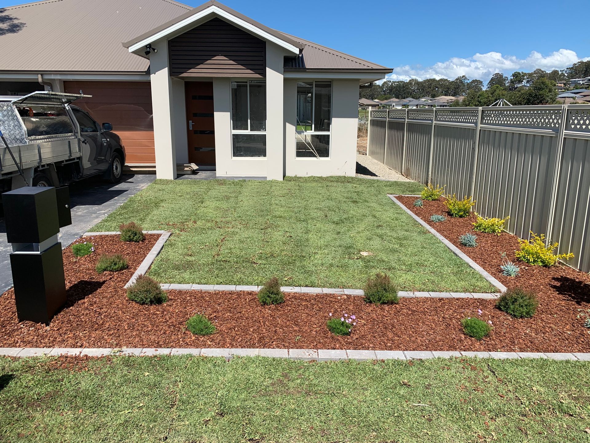 A house with a lawn and a truck parked in front of it.