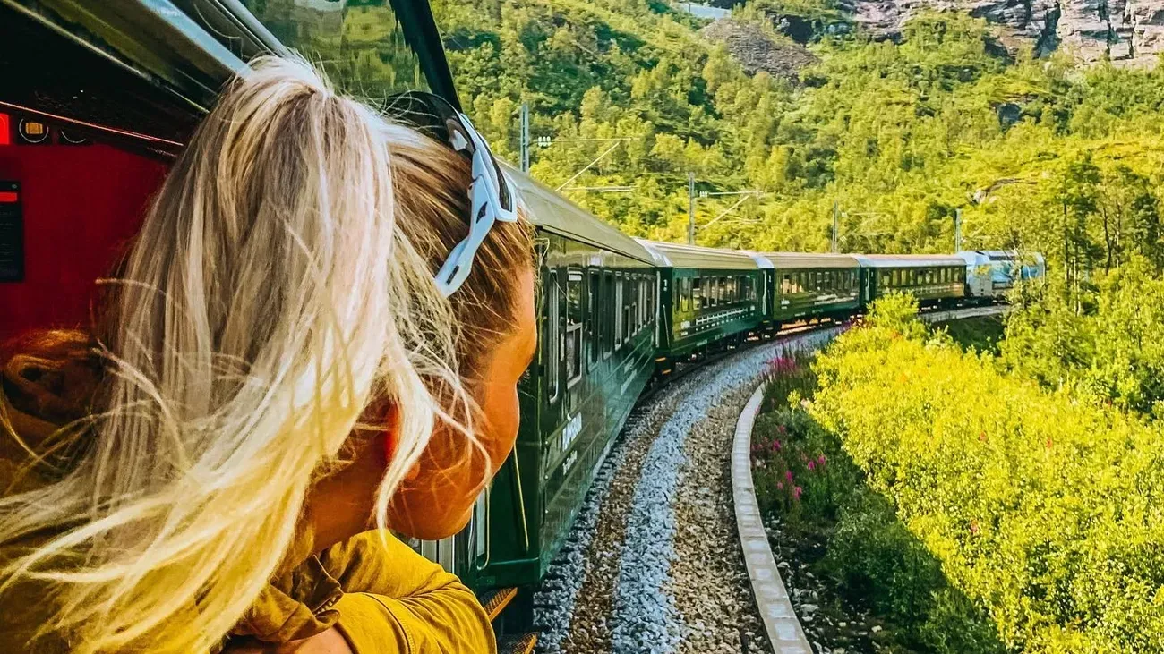 Een vrouw kijkt uit het raam van een trein.