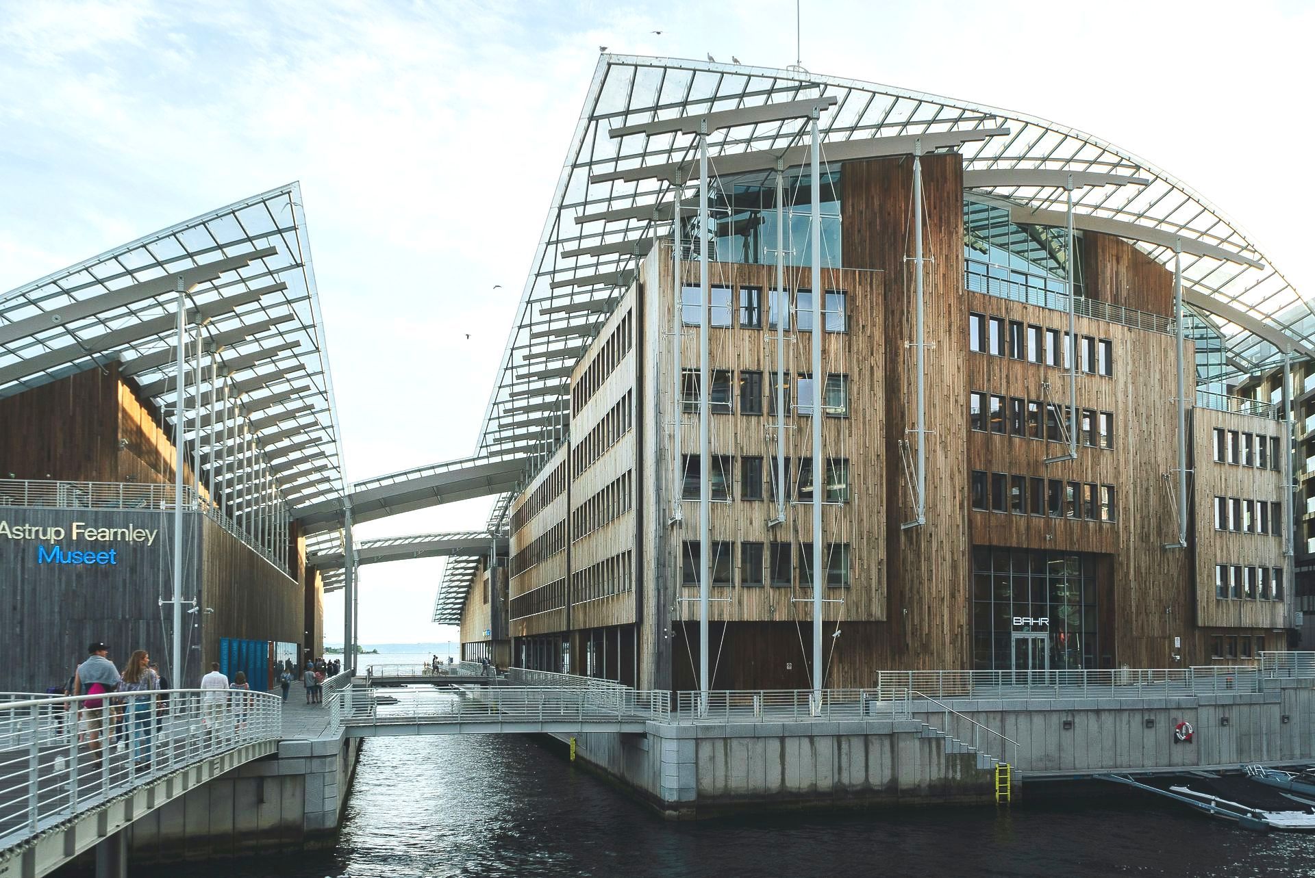Een groot gebouw met een brug over een watermassa
