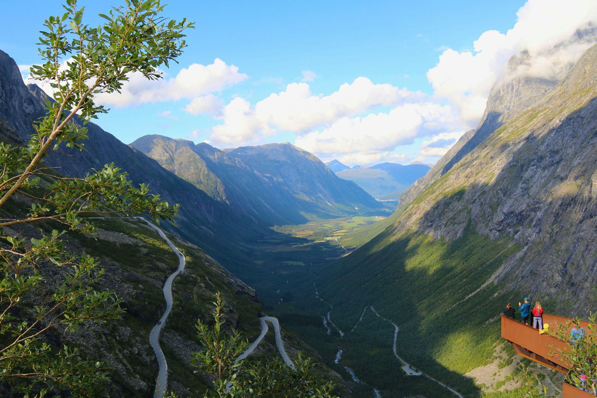Een groep mensen kijkt vanuit een platform naar de Trollstigen