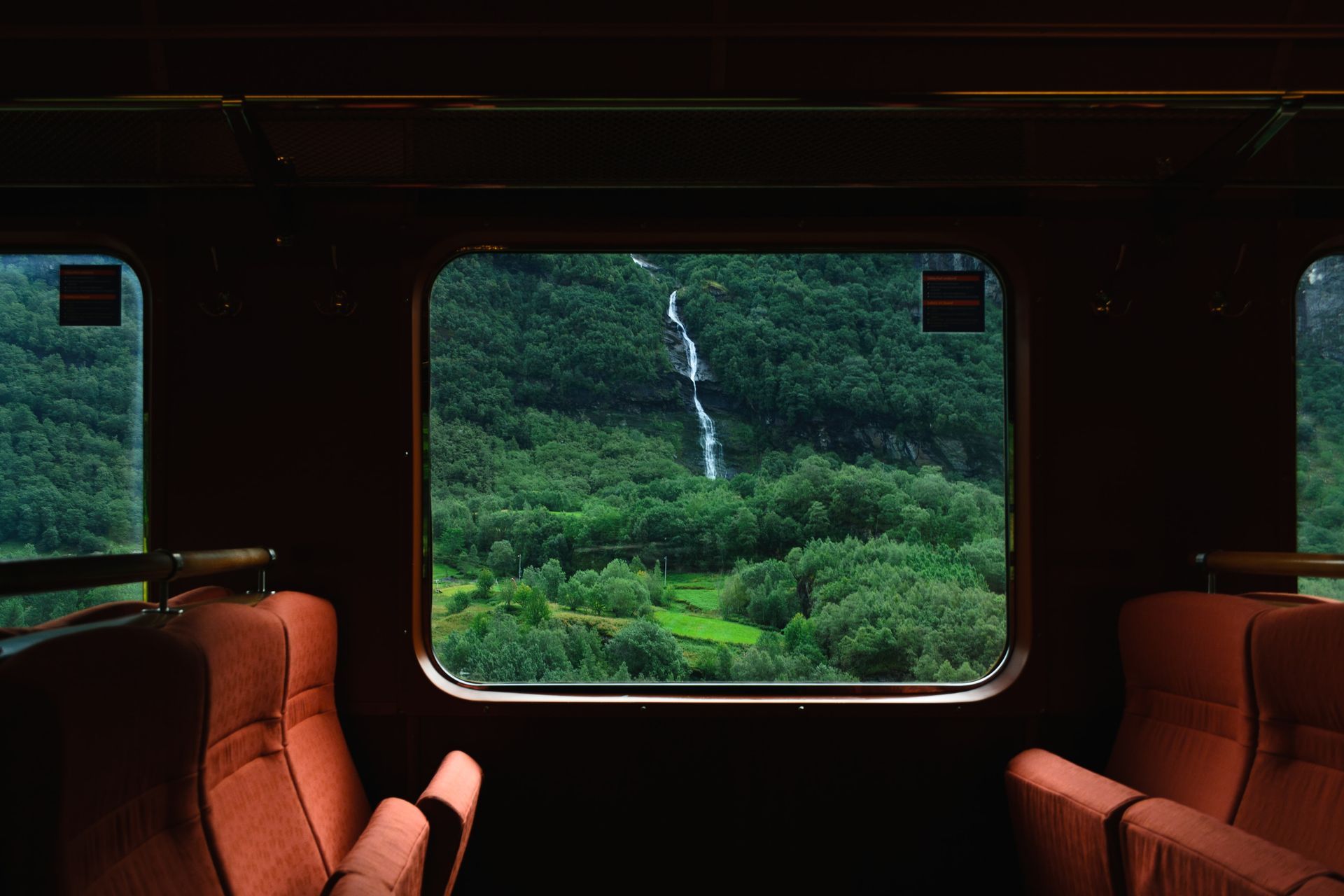Een trein rijdt door een weelderig groen bergdal.