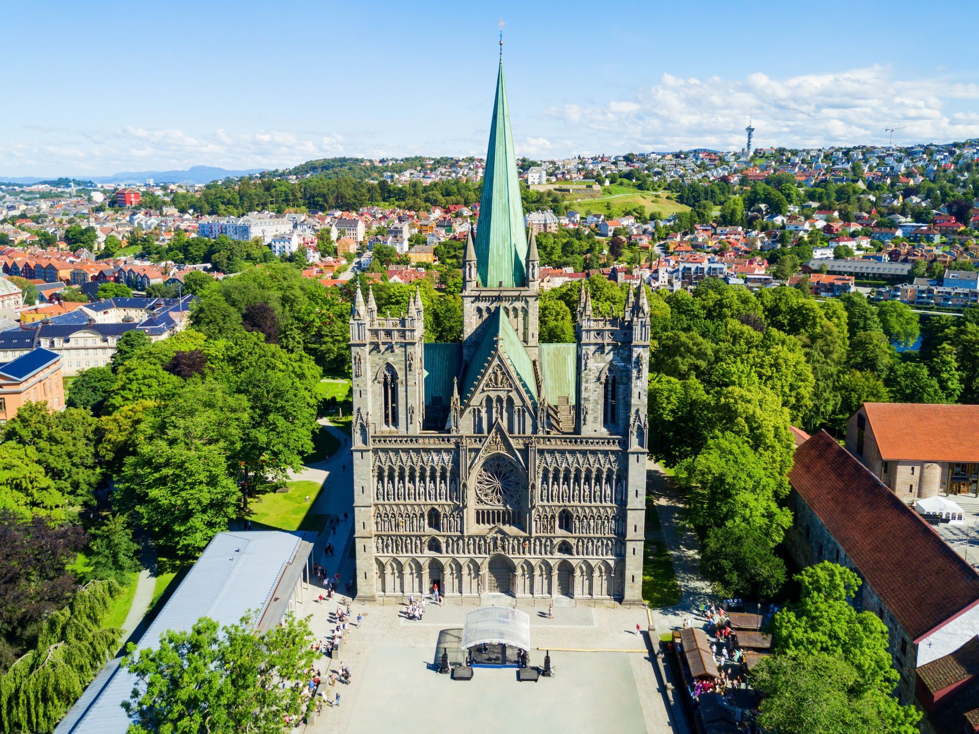 Een luchtfoto van een grote kathedraal omgeven door bomen in een stad.