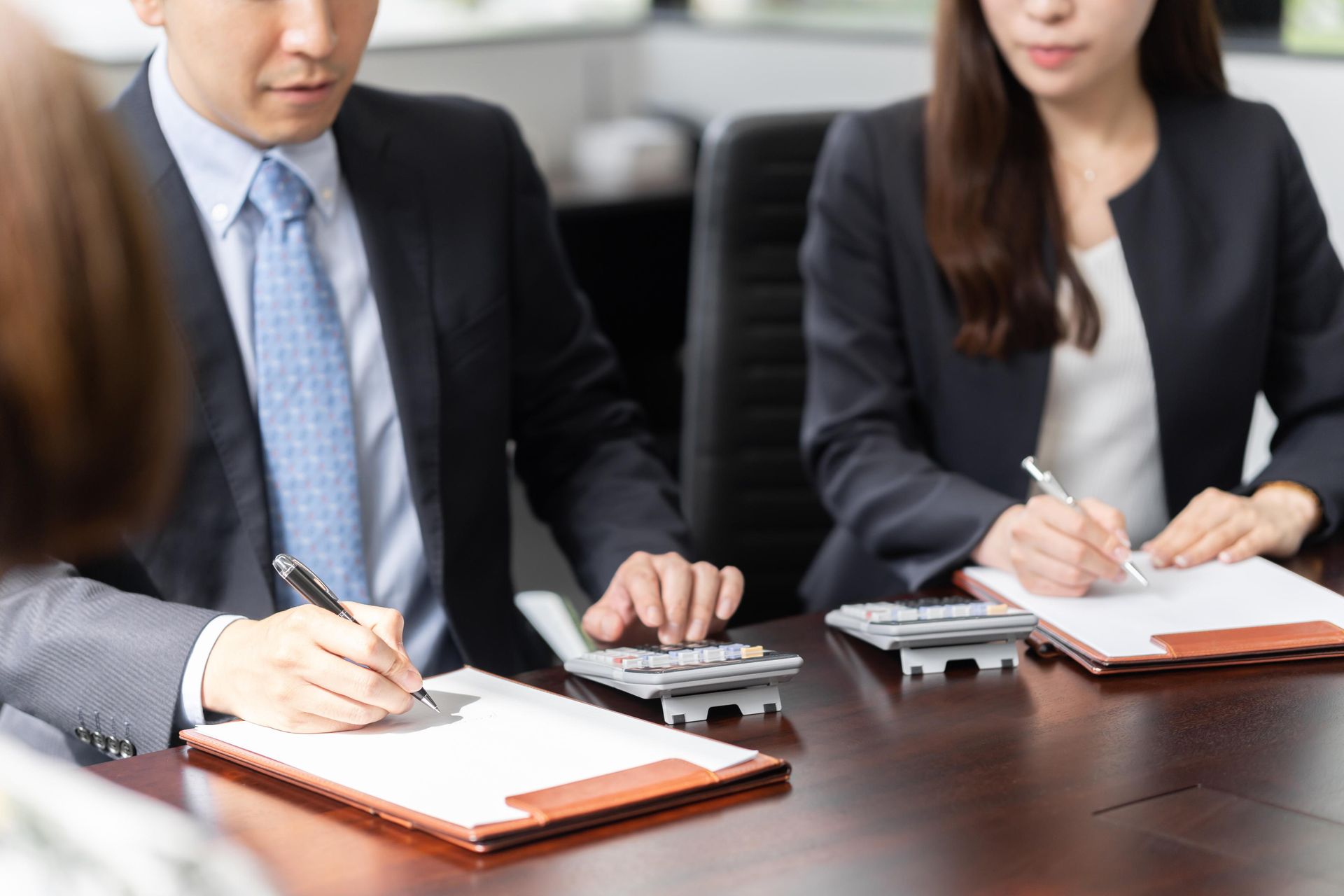 A man and a woman are sitting at a table with calculators.