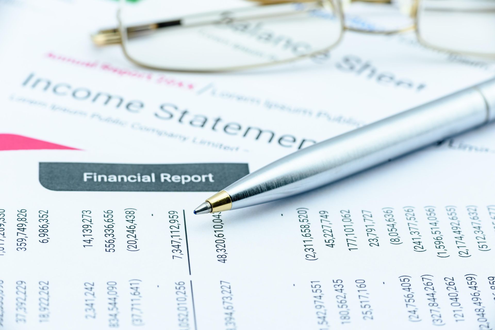 A pen is sitting on top of a financial report.