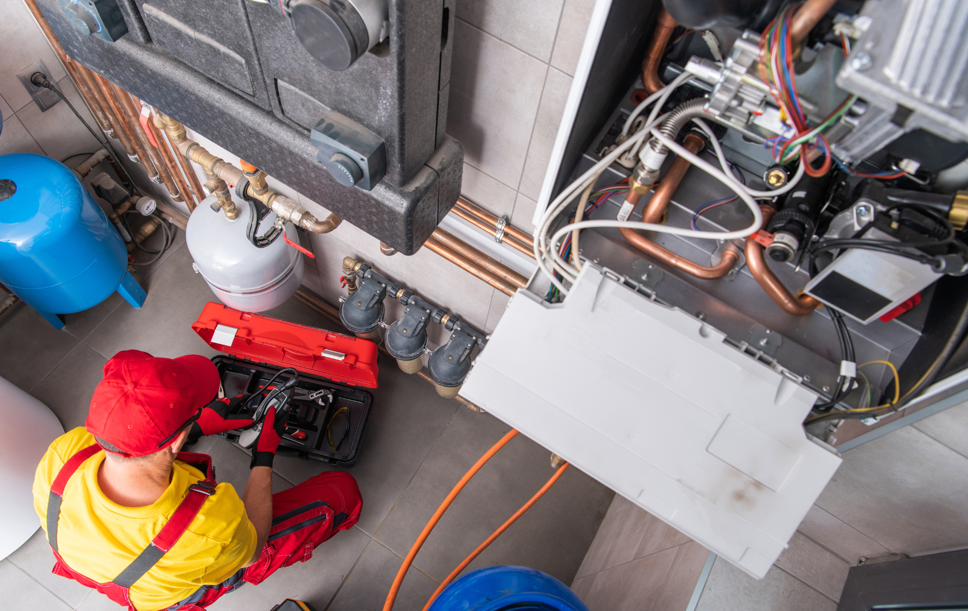 A man is working on a heating system in a room.