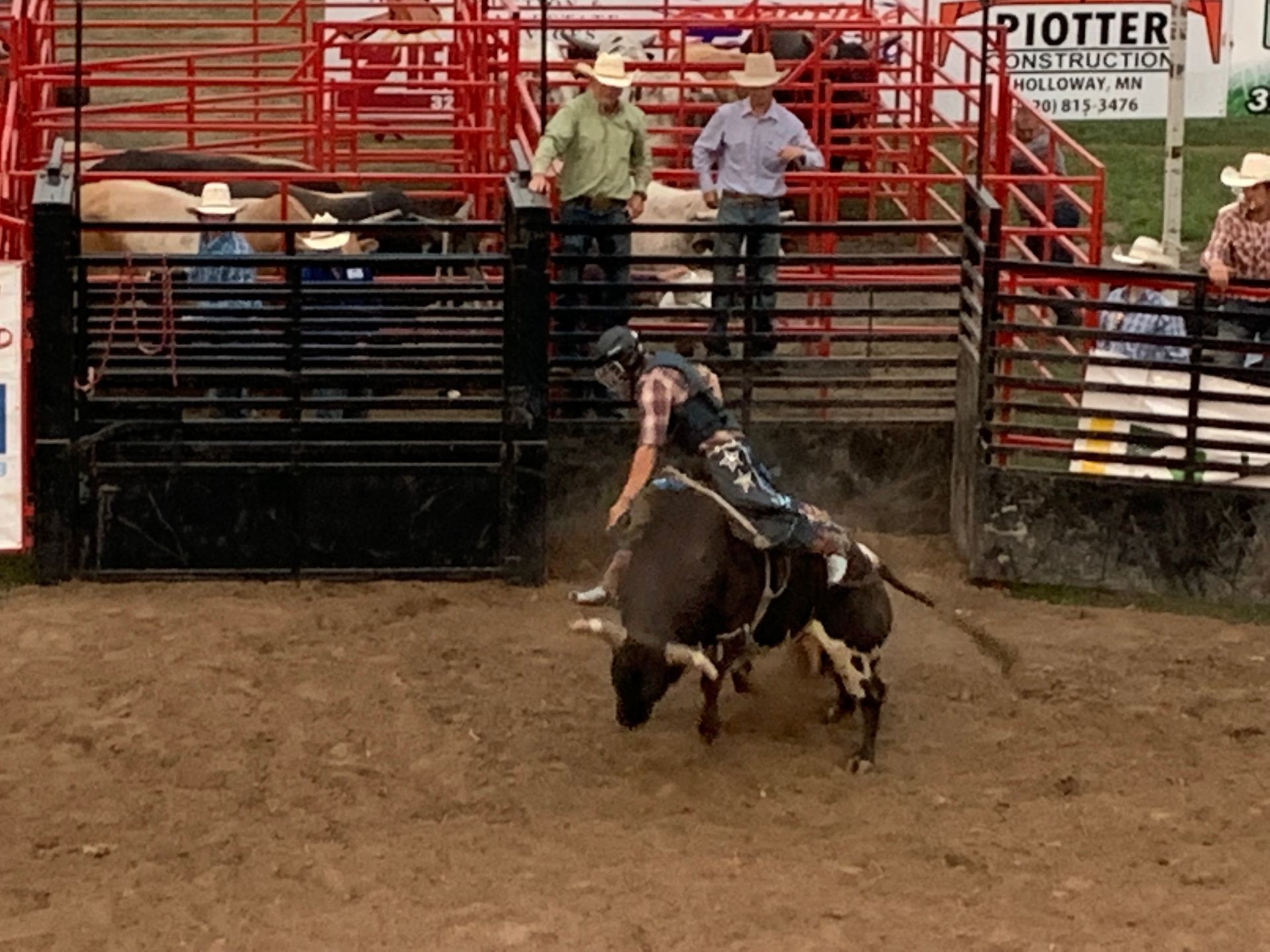 A man riding a bull in a rodeo arena.