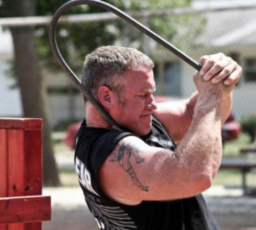 A brown and white rabbit is sitting in a cage.