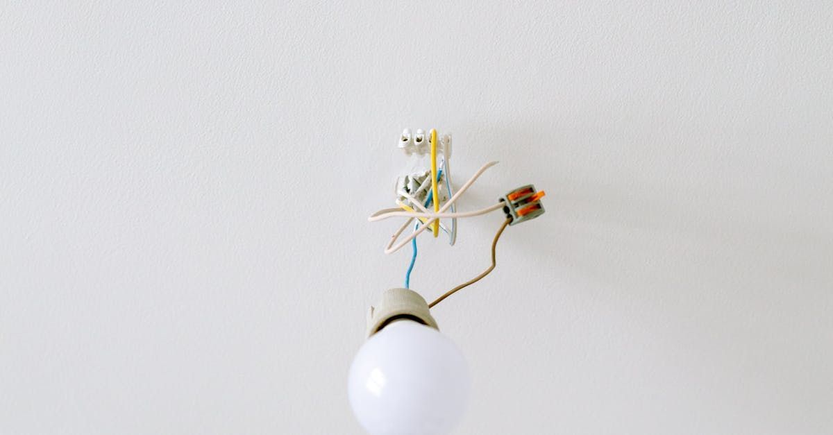 A light bulb is hanging from the ceiling with wires attached to it.