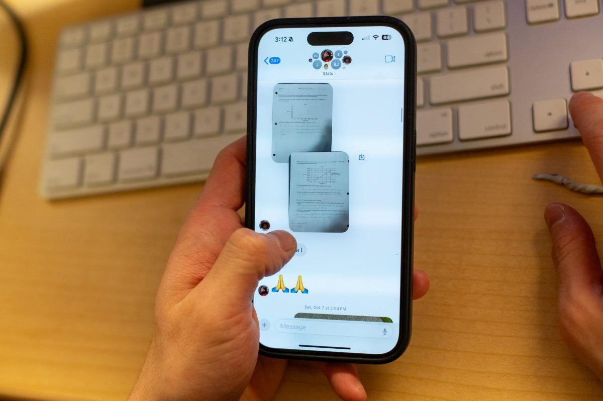 Person using a smartphone, displaying a document with a keyboard in the background.