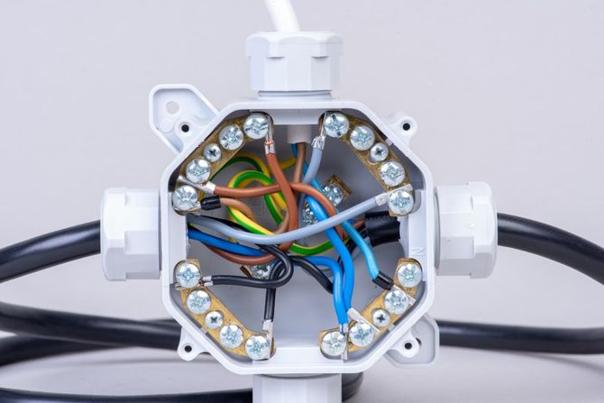 Open electrical junction box with exposed multicolored wires and connectors