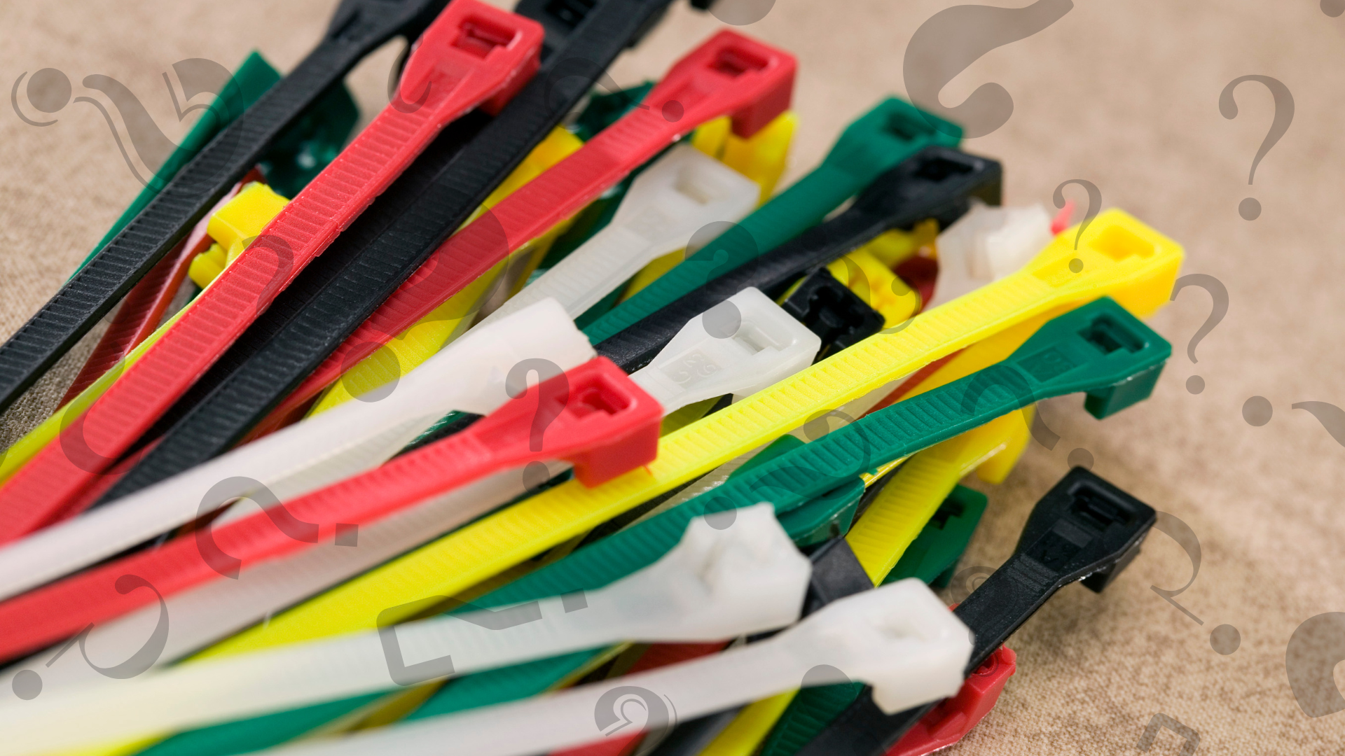 A pile of colorful cable ties with a question mark in the background.