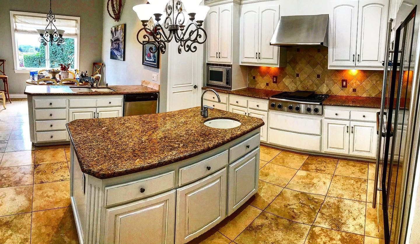Spacious kitchen with two islands, white cabinets, and granite countertops.
