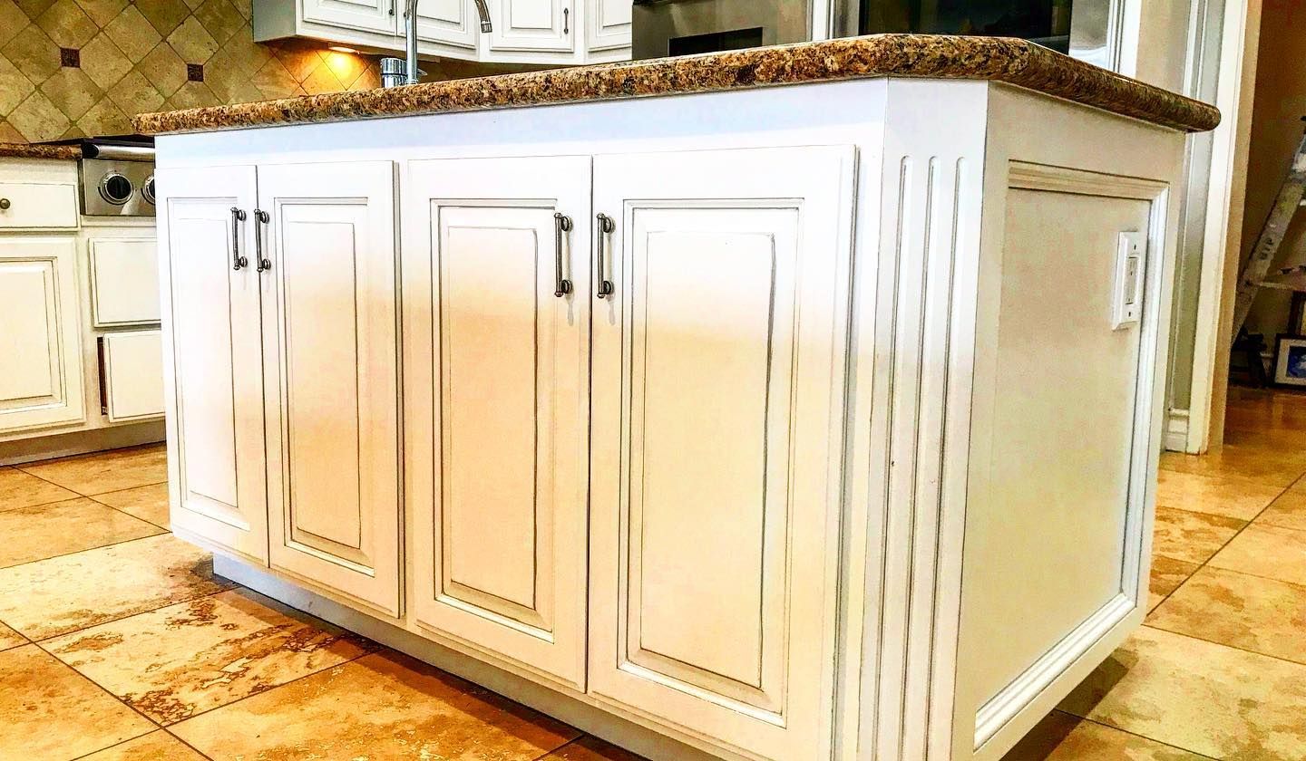 A large white kitchen with granite countertops, stainless steel appliances, and a central island.