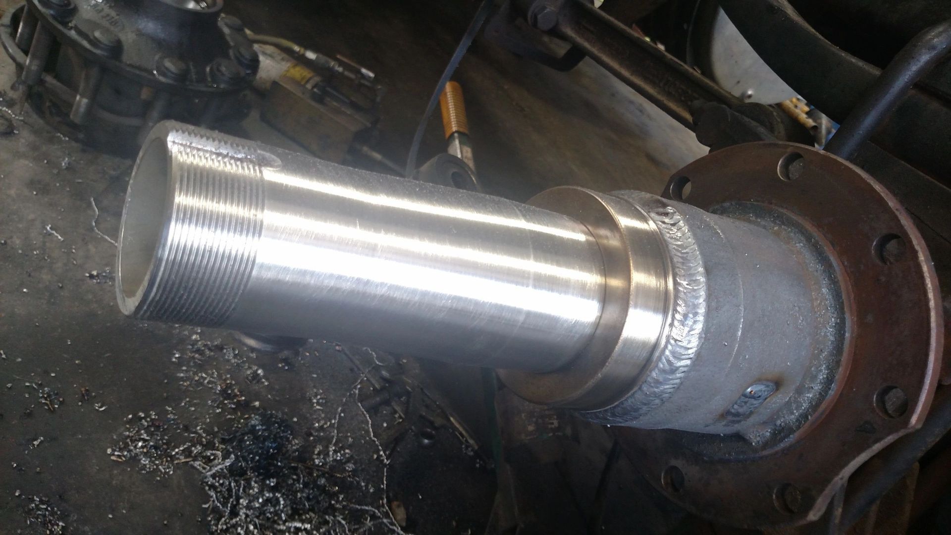 A close up of a metal pipe being cut on a machine.