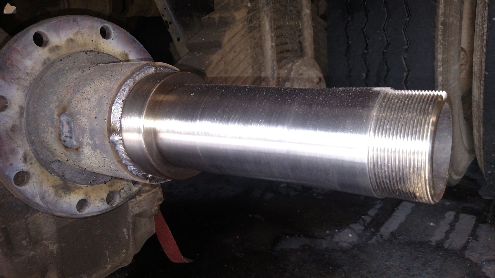 A close up of a metal pipe sitting on top of a tire.