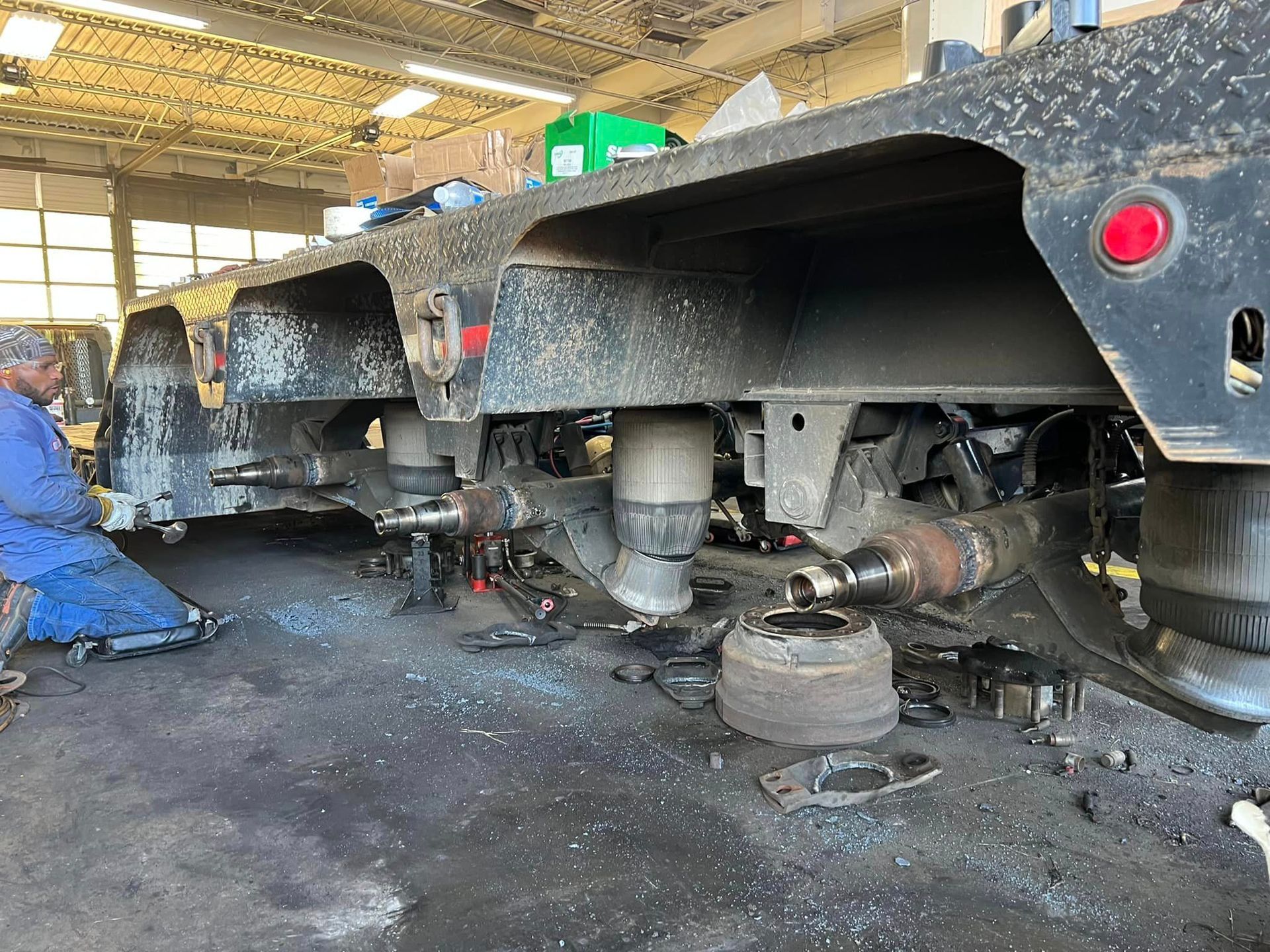 A man is working on a semi truck in a garage.
