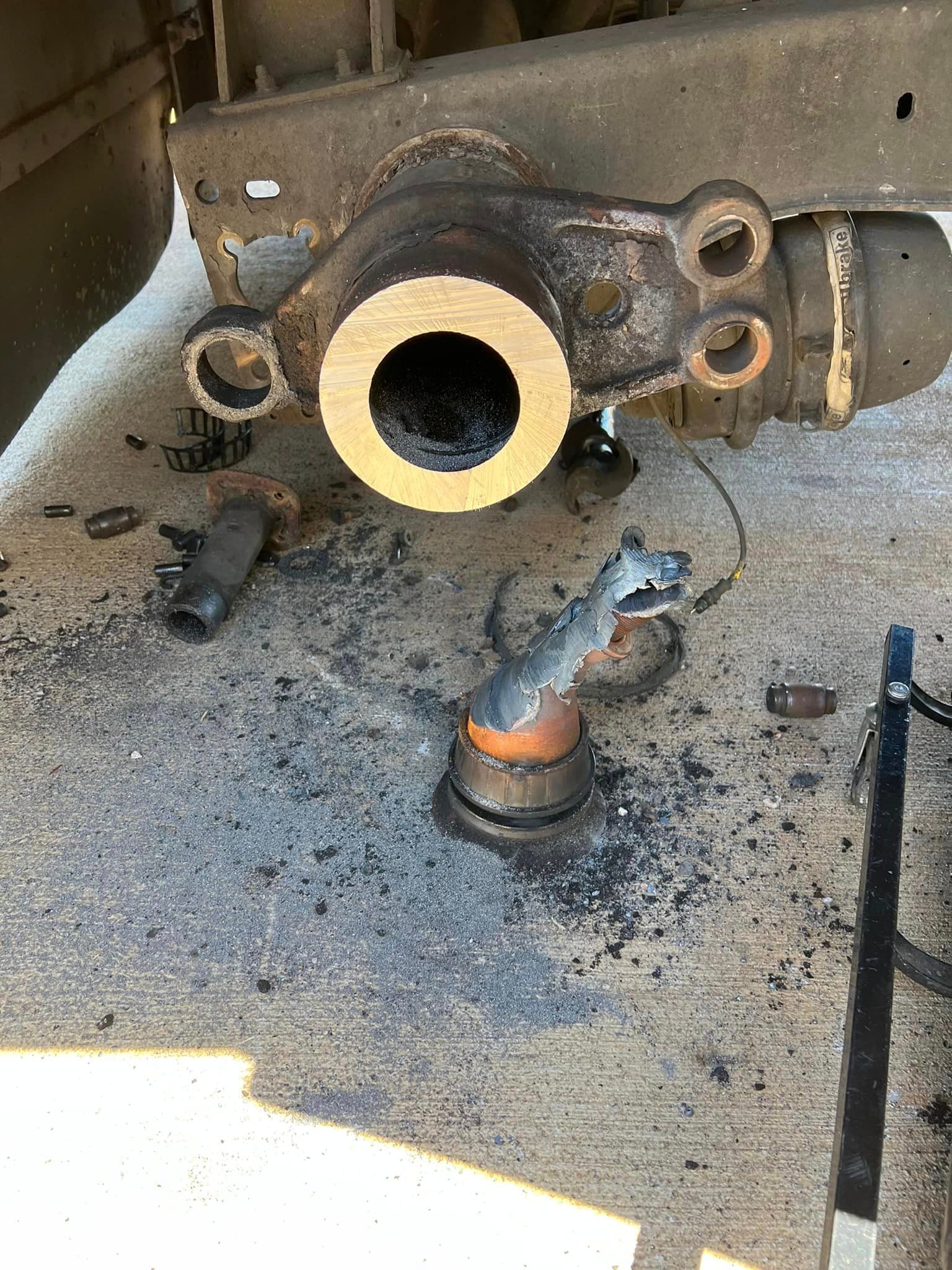 A piece of metal with a hole in it is sitting on the ground.