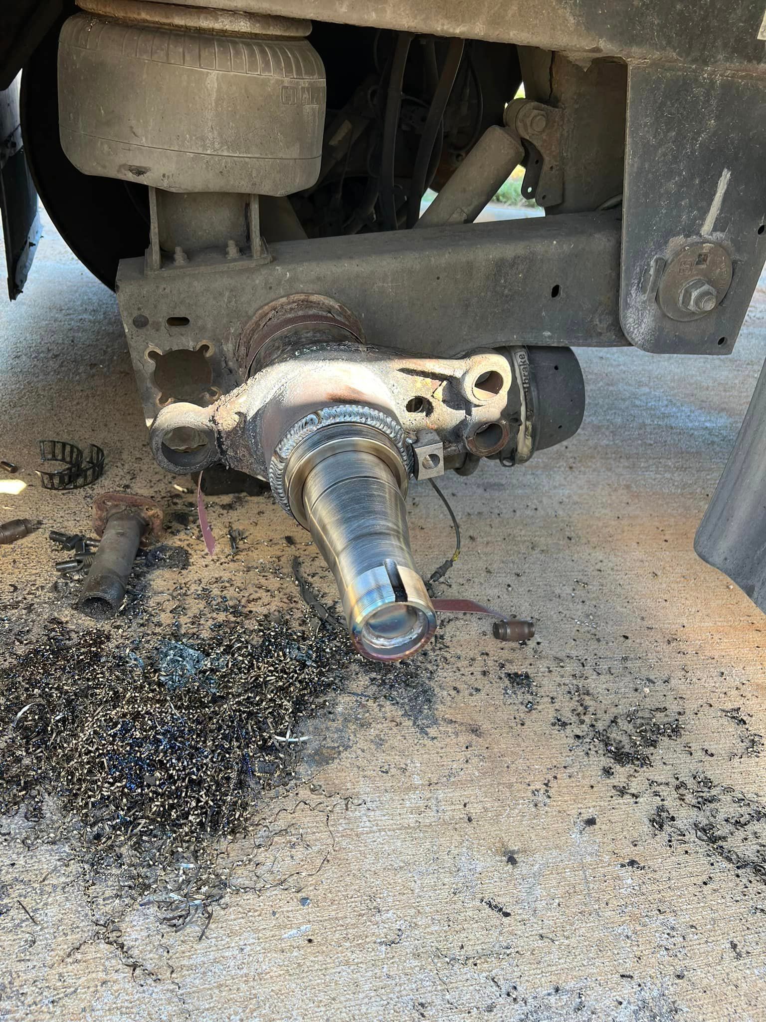 A close up of a broken trailer hitch on the ground.