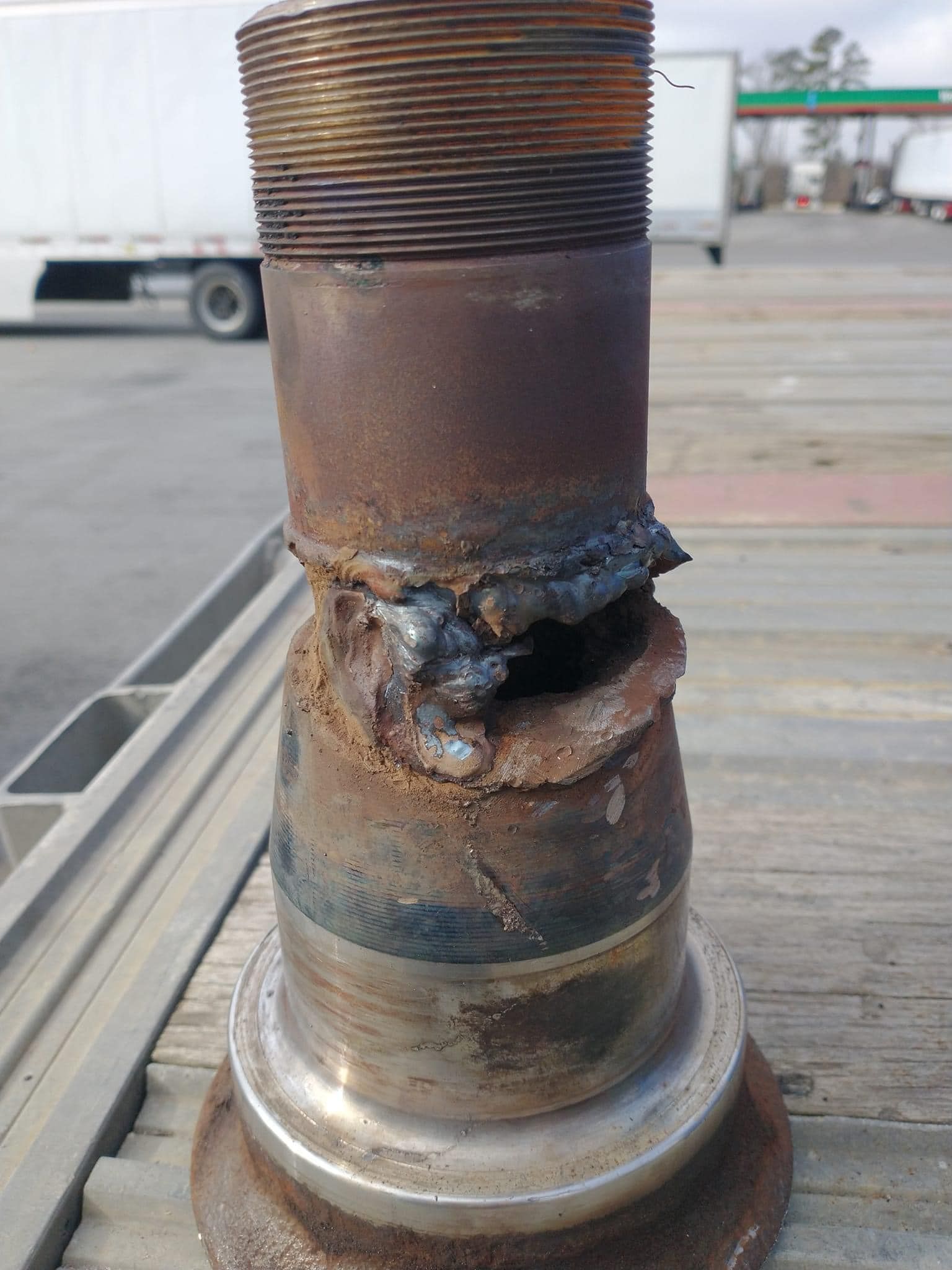 A rusty metal object is sitting on top of a wooden table.