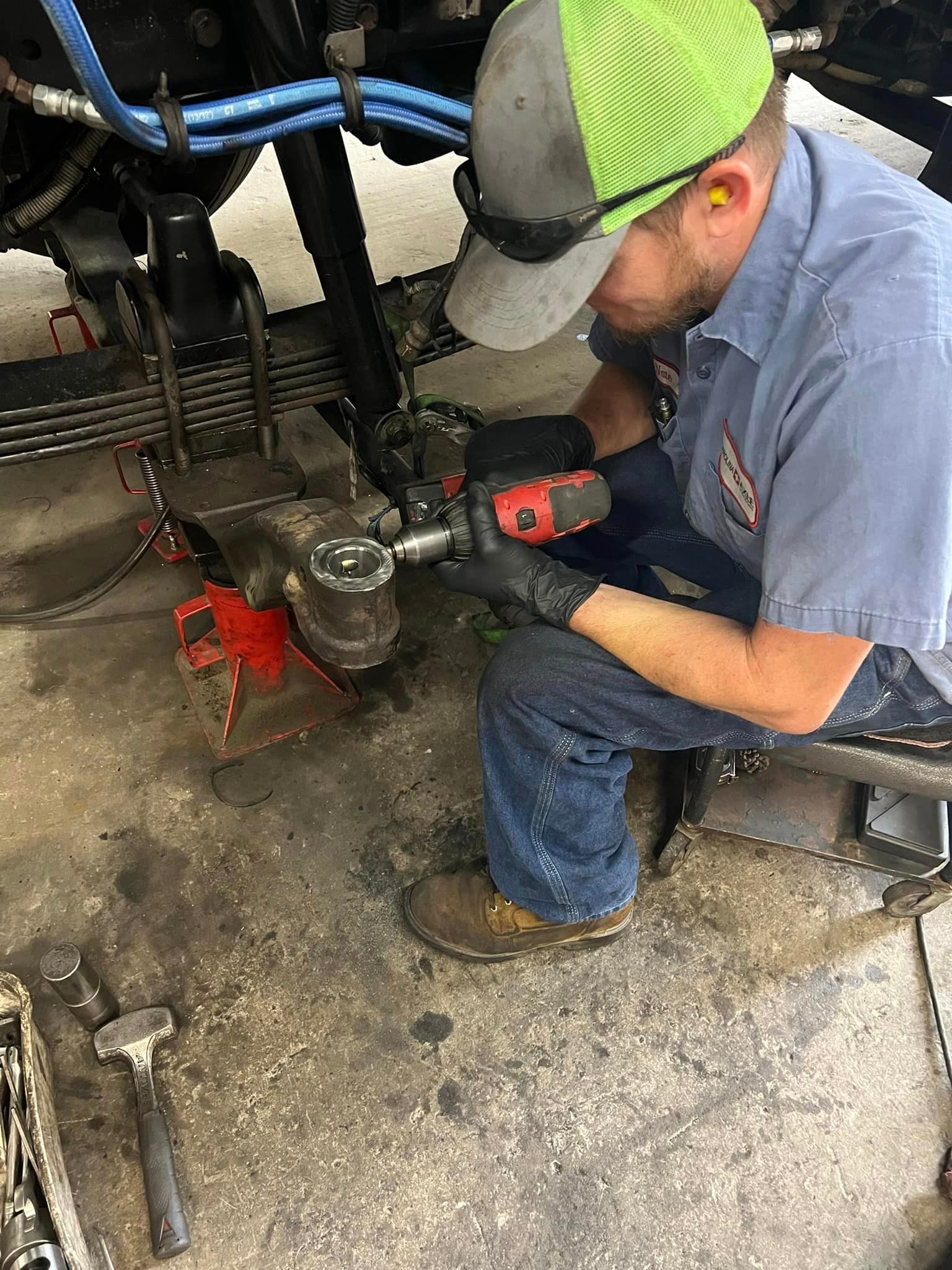 A man is working on a truck in a garage.