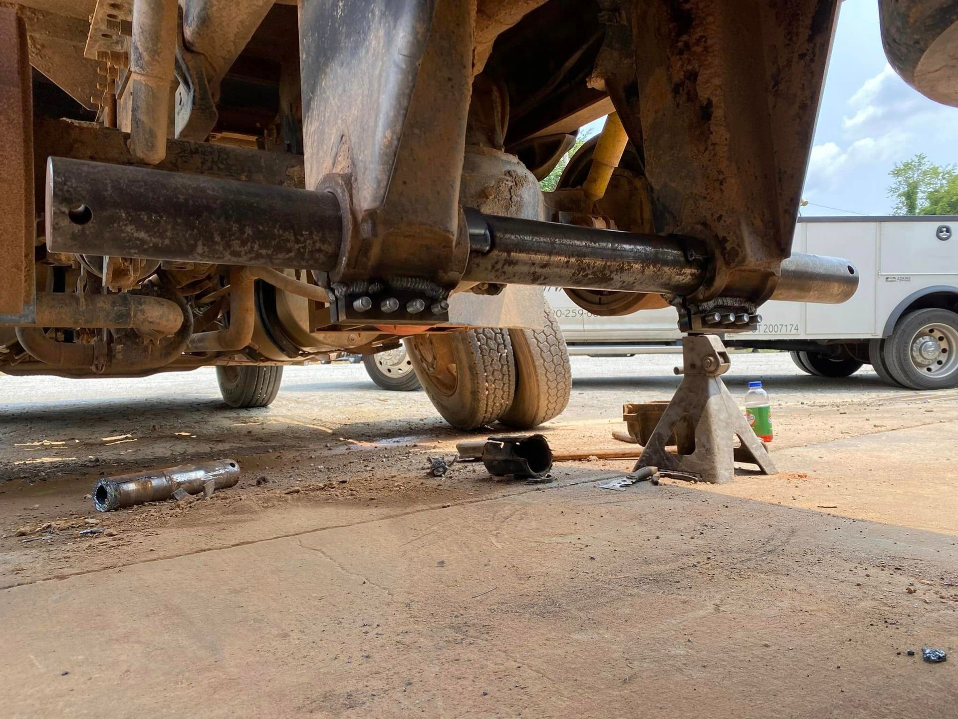 A truck is sitting on a jack in a parking lot.