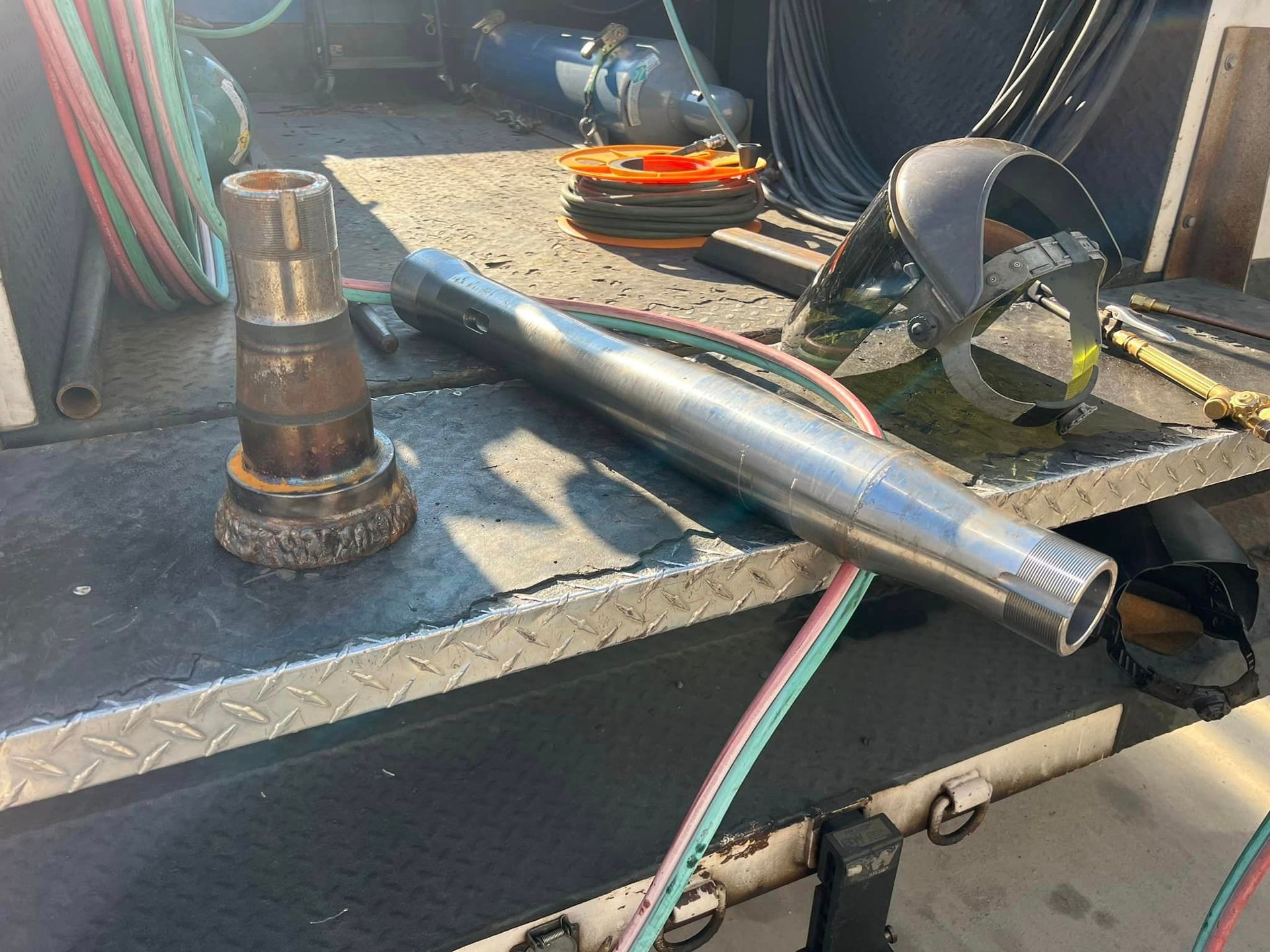 A metal pipe is sitting on top of a metal table.