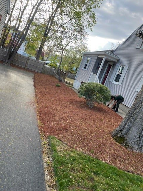 A person is kneeling down in front of a house.