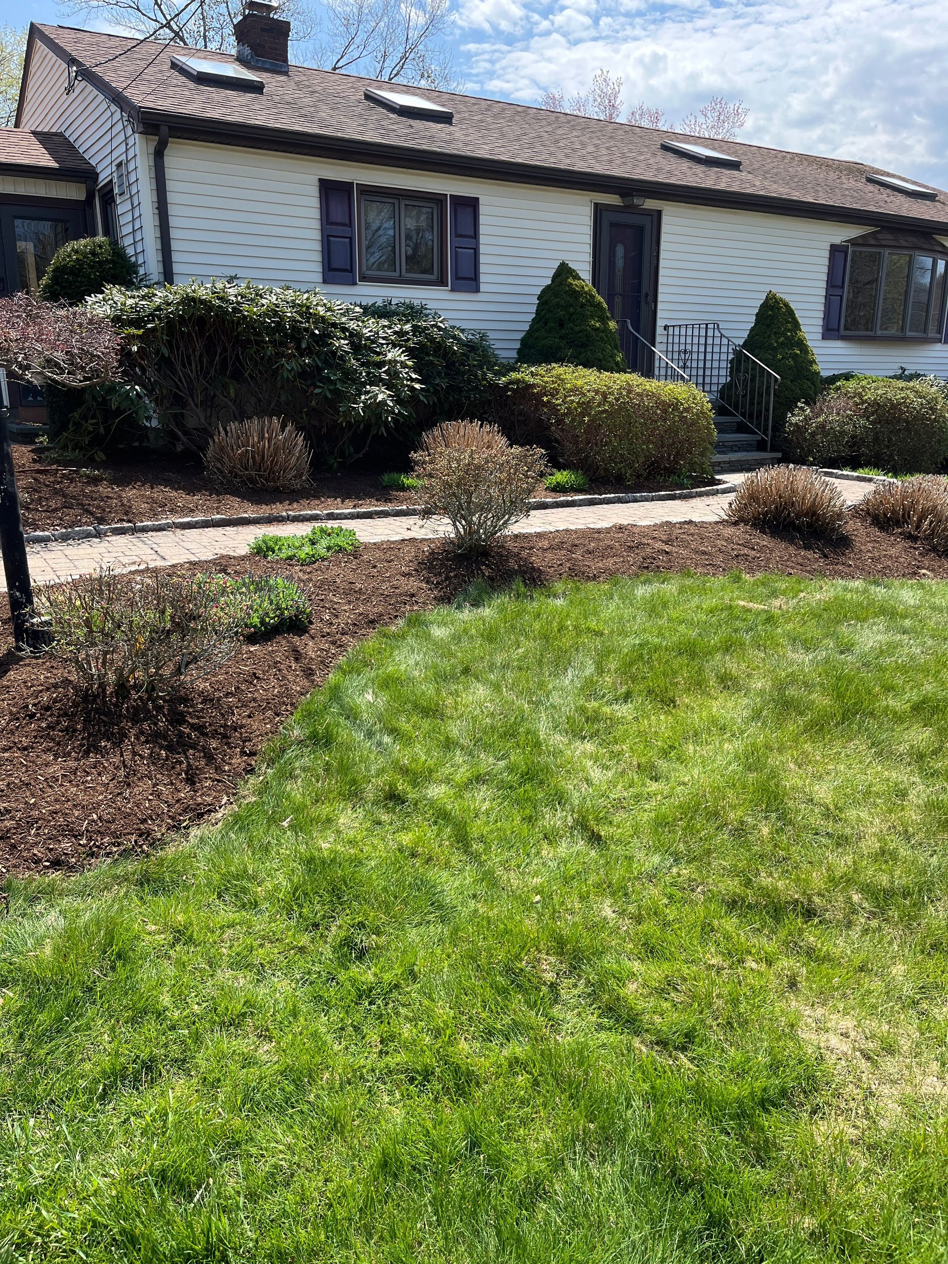 A white house with a lush green lawn in front of it.