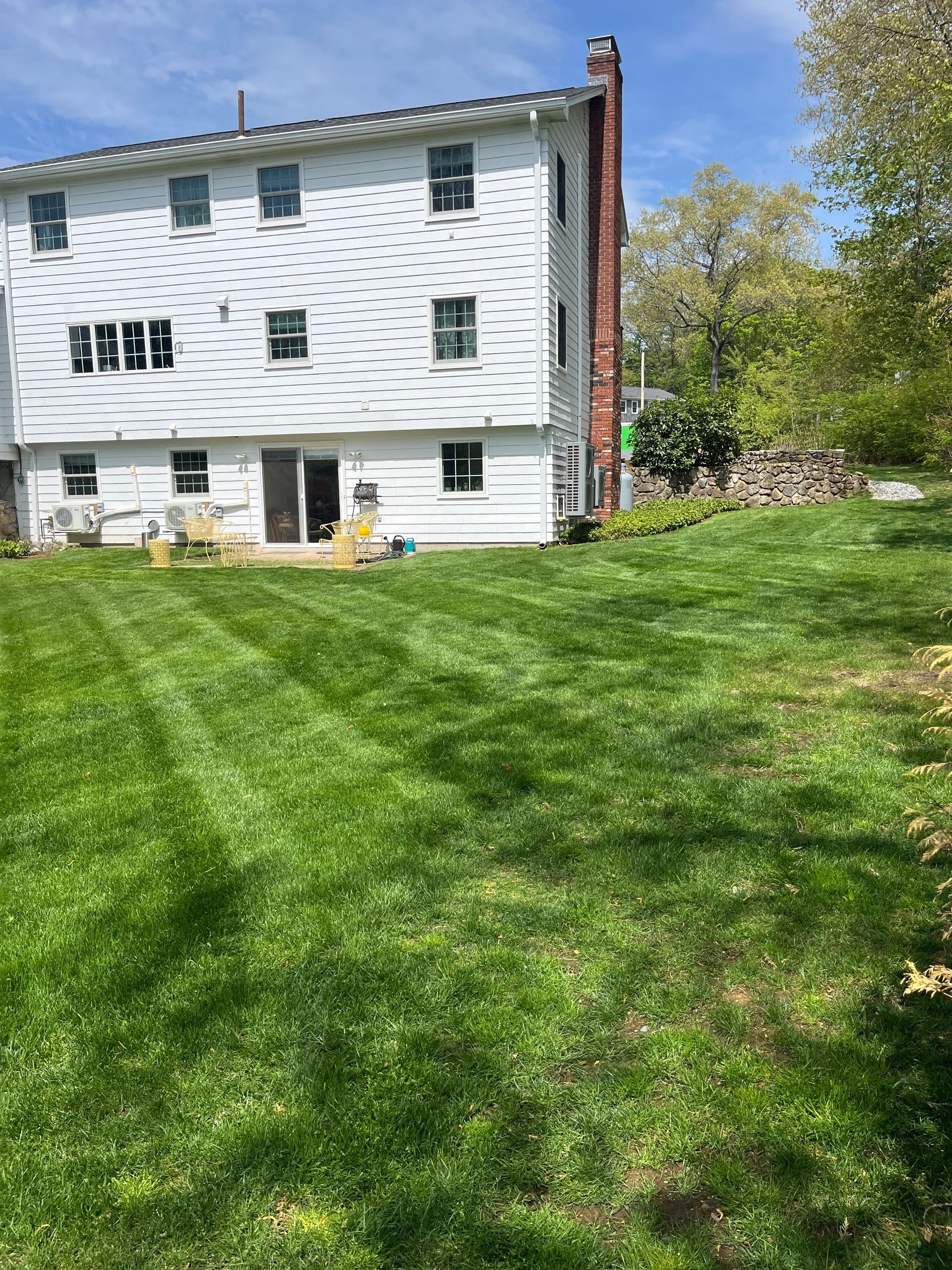 A large white house with a lush green lawn in front of it.