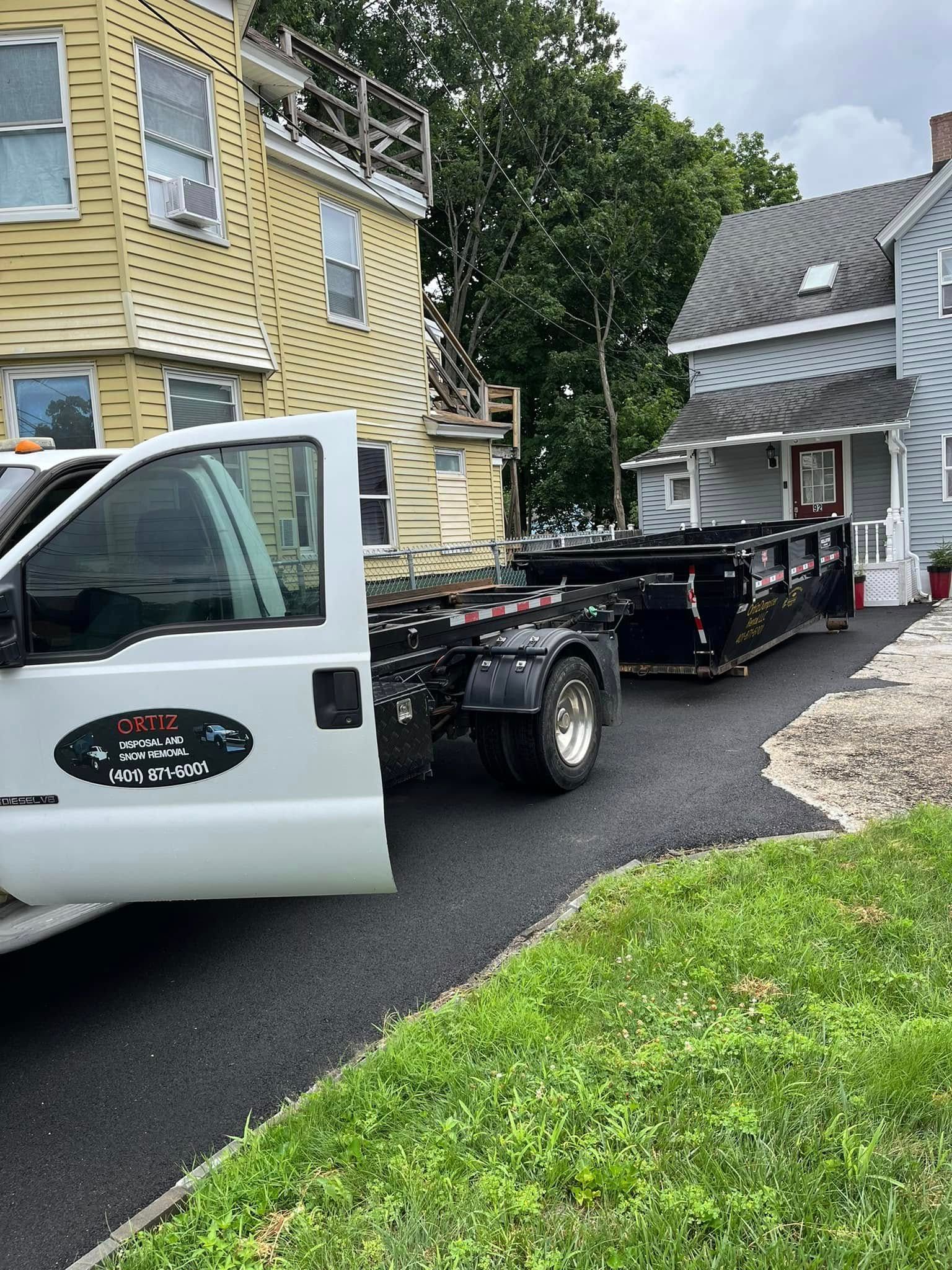 A white tow truck is parked in front of a house.