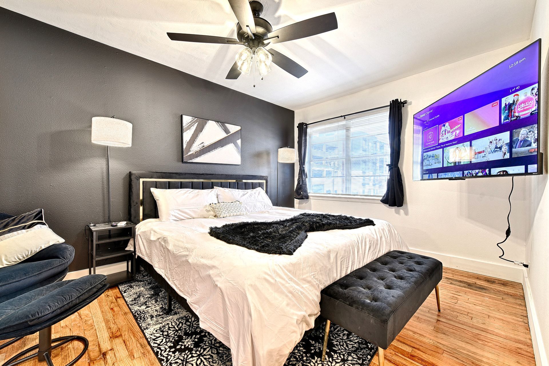 A bedroom with a large bed and a flat screen tv on the wall.