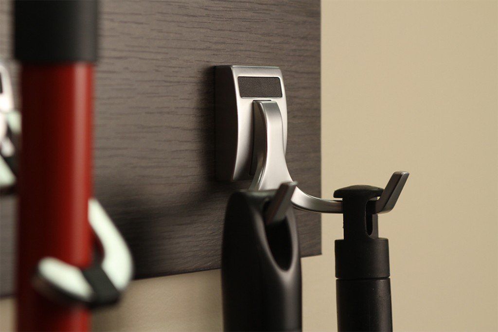 A close up of a hook on a wall with a red and black object hanging from it.
