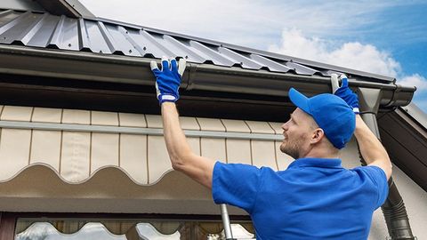 Gutter Repair — Man Installing House Roof Rain Gutter in Kenner, LA