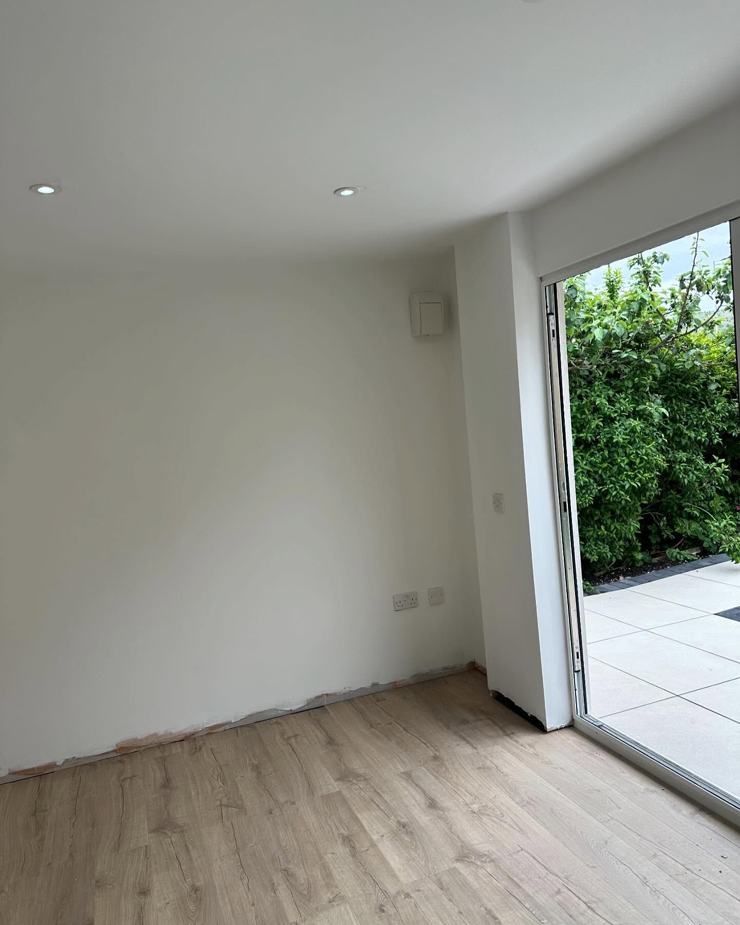 An empty room with a sliding glass door leading to a patio.