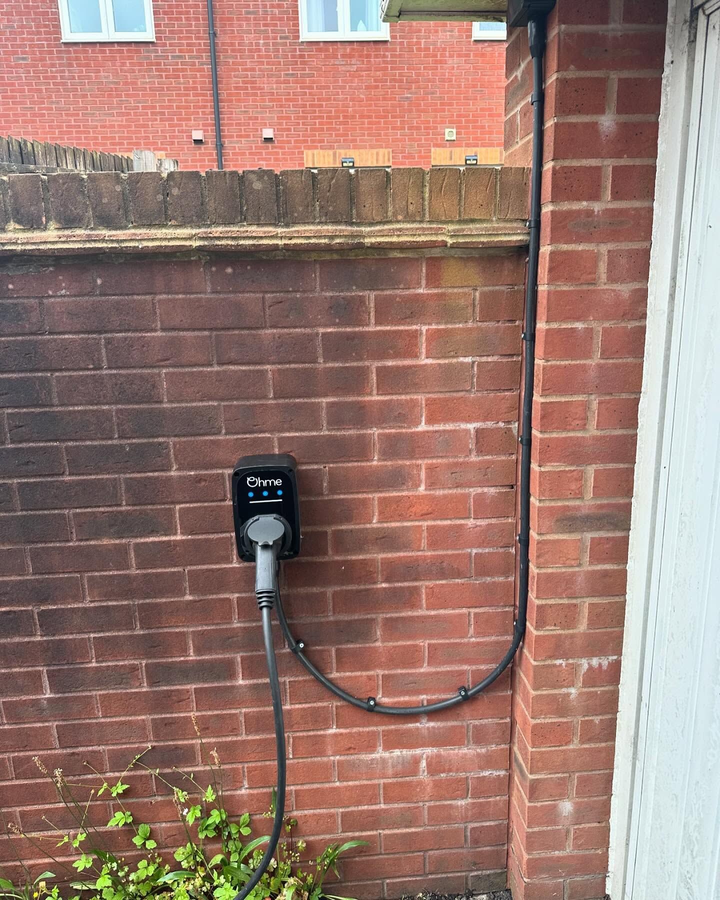A brick wall with a charging station attached to it.