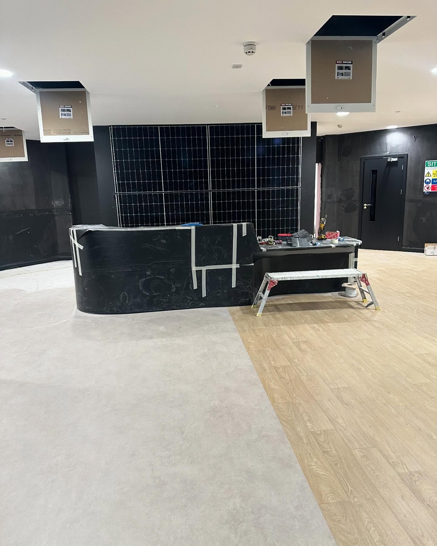 A large room with a black counter and a wooden floor.
