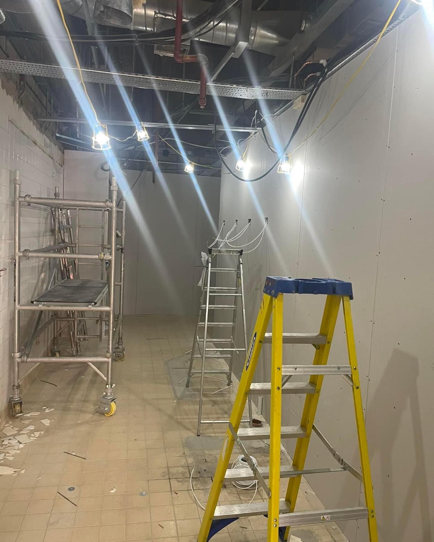 A yellow ladder is sitting in the middle of a room.